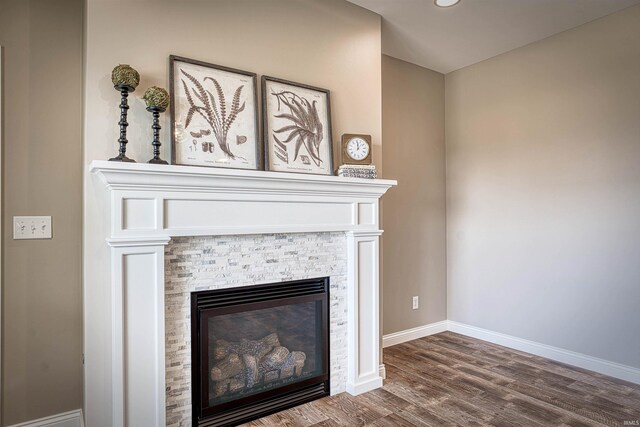 room details with hardwood / wood-style flooring and a stone fireplace