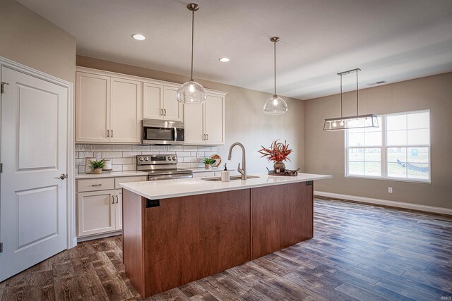 kitchen with dark hardwood / wood-style floors, a center island with sink, pendant lighting, stainless steel appliances, and sink