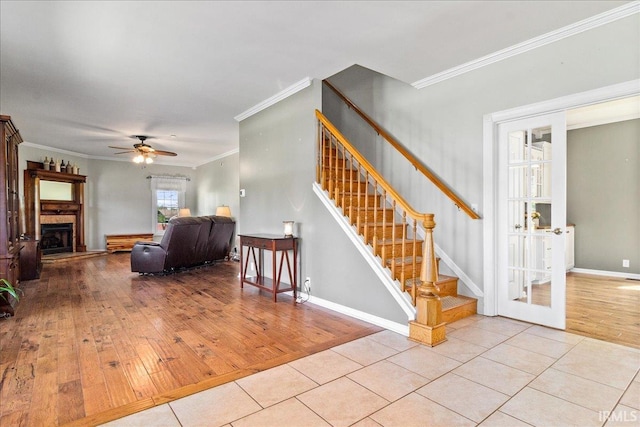 stairway with ornamental molding, hardwood / wood-style flooring, and ceiling fan