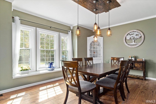 dining space featuring wood-type flooring and ornamental molding