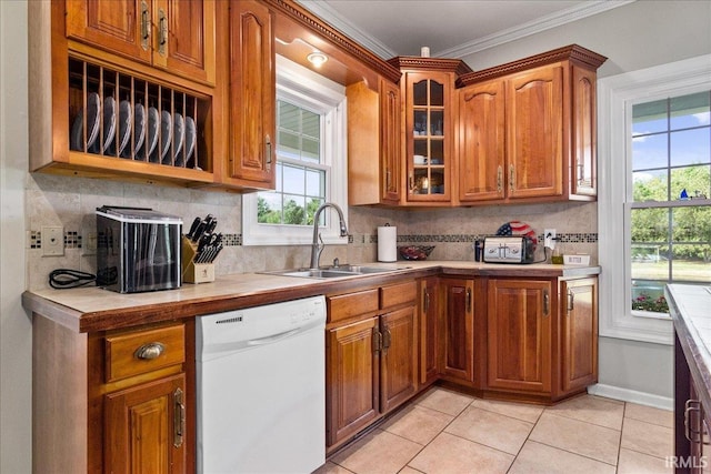 kitchen with crown molding, backsplash, light tile patterned floors, white dishwasher, and sink