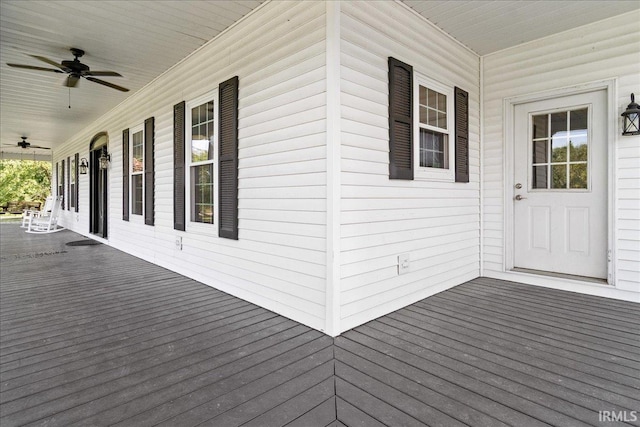 wooden terrace with ceiling fan and covered porch