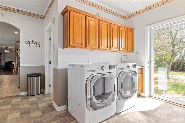 washroom with ceiling fan, ornamental molding, cabinets, and washer and dryer