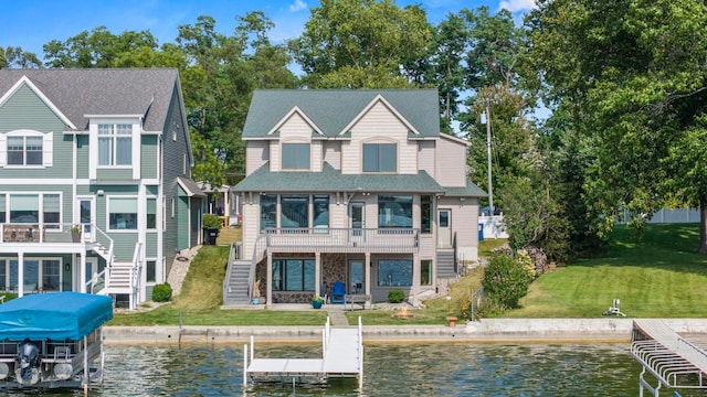 back of house with a water view and a yard