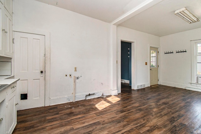 unfurnished dining area with dark wood-type flooring and baseboard heating