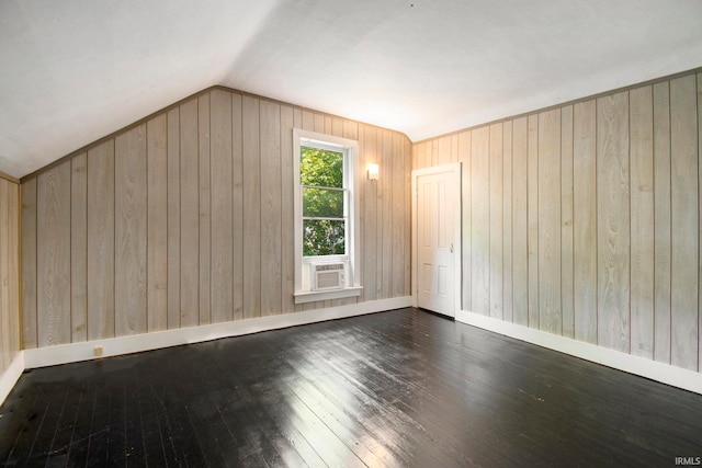 bonus room featuring dark wood-type flooring, vaulted ceiling, and wooden walls