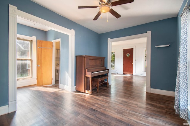 empty room featuring plenty of natural light, ceiling fan, and dark hardwood / wood-style floors