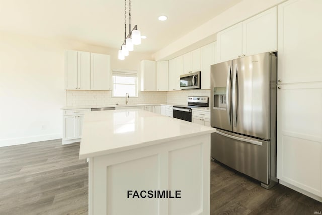 kitchen with dark wood-type flooring, white cabinets, decorative light fixtures, a kitchen island, and stainless steel appliances