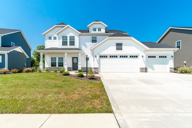 view of front of house with a garage, covered porch, and a front lawn