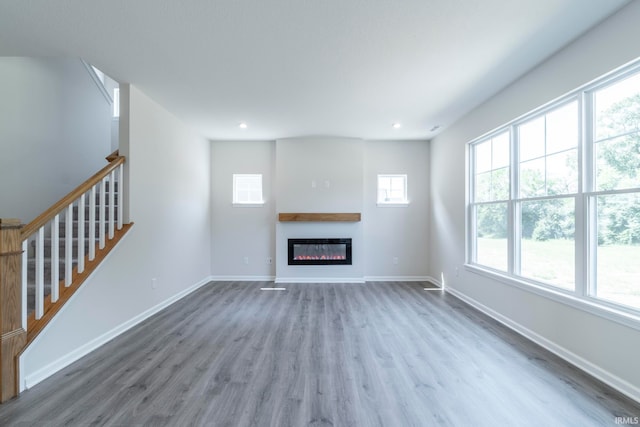 unfurnished living room with hardwood / wood-style flooring and a healthy amount of sunlight