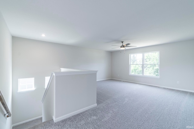 carpeted spare room featuring ceiling fan