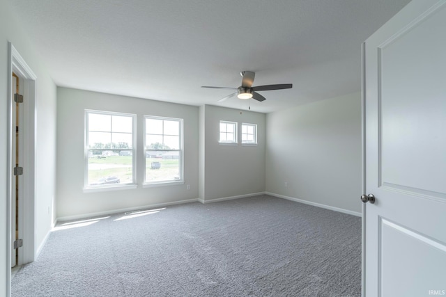 carpeted spare room featuring ceiling fan