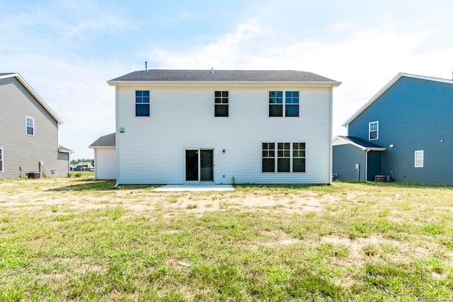 rear view of house featuring a lawn, a patio area, and central AC