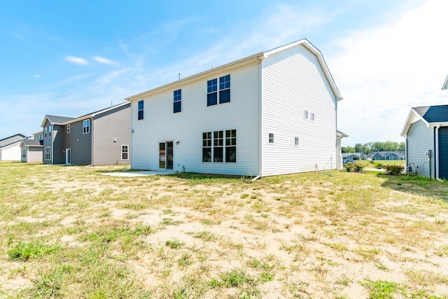 rear view of property featuring a yard and a patio