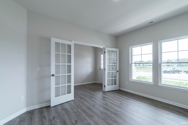 spare room with hardwood / wood-style flooring and french doors