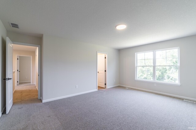 spare room with a textured ceiling and carpet floors