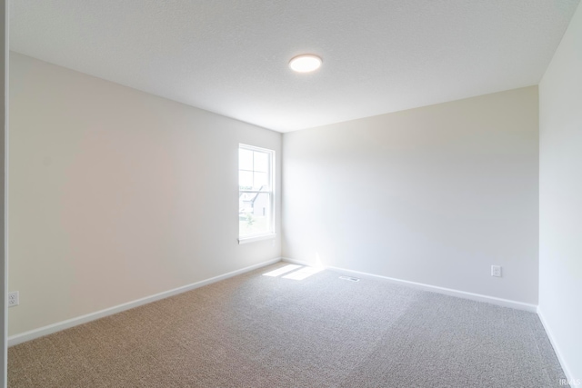 unfurnished room featuring a textured ceiling and carpet floors