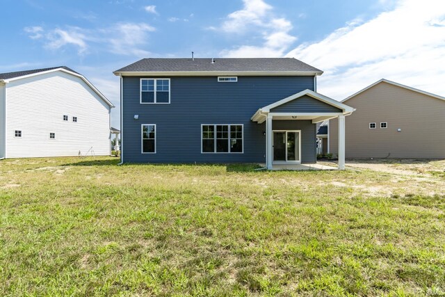 rear view of house featuring a lawn and a patio area