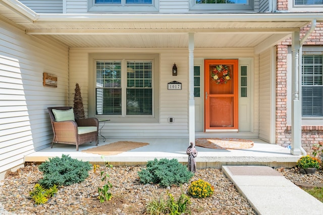 view of exterior entry featuring covered porch