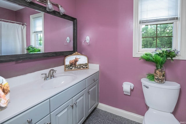 bathroom featuring toilet, plenty of natural light, and vanity