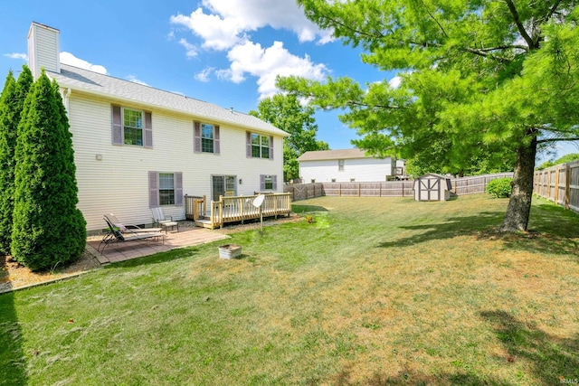 exterior space with a yard, a storage unit, and a deck