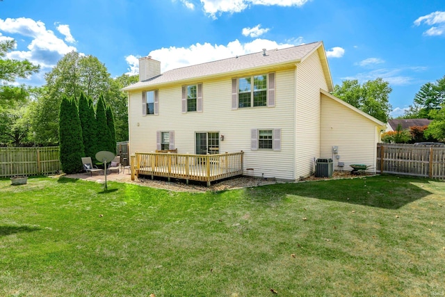 back of property with a yard, a wooden deck, and cooling unit