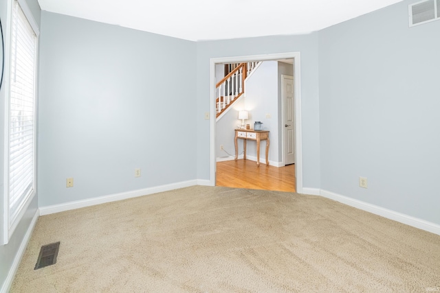 unfurnished room featuring light carpet