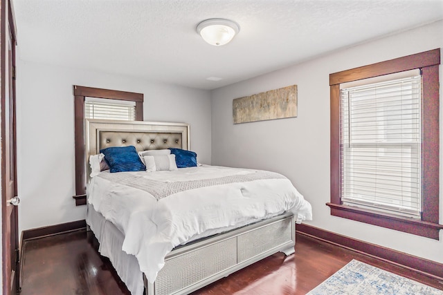 bedroom featuring a textured ceiling and dark hardwood / wood-style flooring