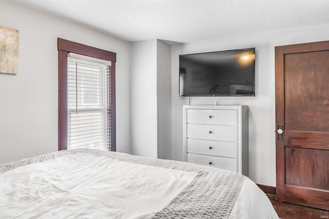 bedroom featuring a textured ceiling and dark hardwood / wood-style floors