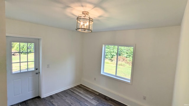 entryway with an inviting chandelier and dark hardwood / wood-style flooring