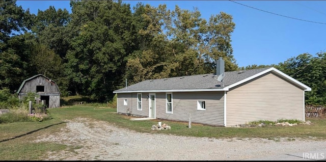 view of property exterior with an outbuilding and a lawn