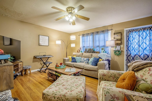 living room featuring a textured ceiling, light hardwood / wood-style flooring, and ceiling fan