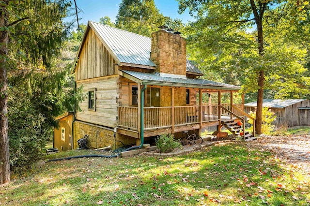 exterior space featuring metal roof, a yard, and a chimney