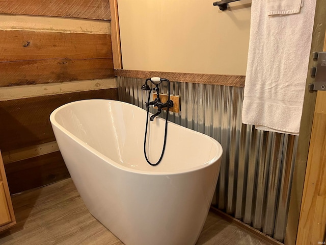 bathroom featuring a bathtub, wooden walls, and hardwood / wood-style floors