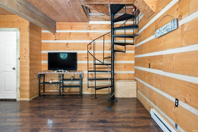 interior space featuring hardwood / wood-style flooring, wood walls, and a baseboard heating unit