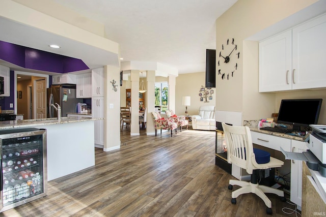 office space featuring dark hardwood / wood-style floors, beverage cooler, and sink