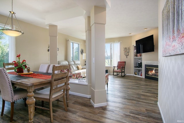 dining space with dark hardwood / wood-style floors and a tiled fireplace