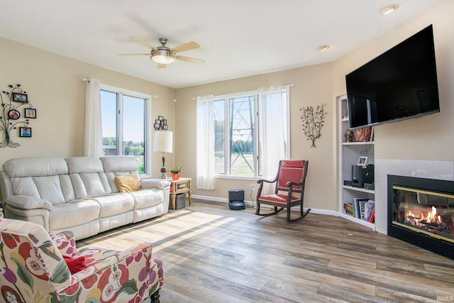 living room with hardwood / wood-style floors, a fireplace, and ceiling fan