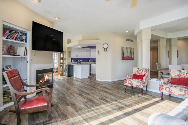 living room featuring hardwood / wood-style floors, a fireplace, and sink