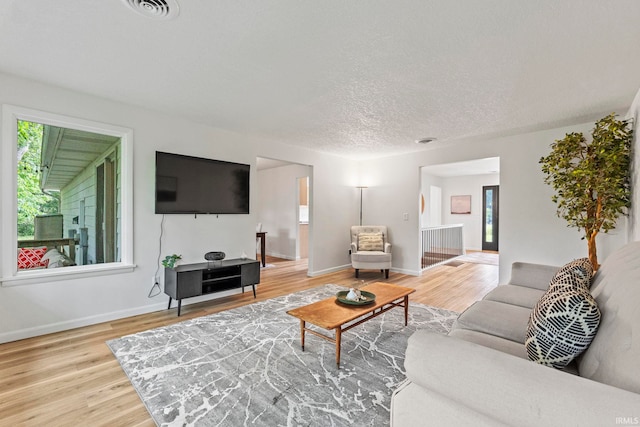 living room with a textured ceiling and light hardwood / wood-style flooring