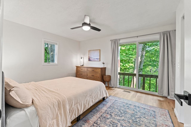 bedroom featuring a textured ceiling, light hardwood / wood-style flooring, and ceiling fan