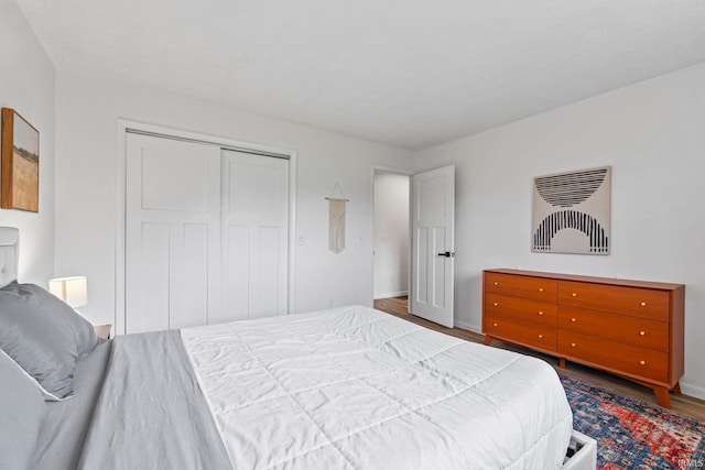 bedroom with a closet and dark hardwood / wood-style flooring