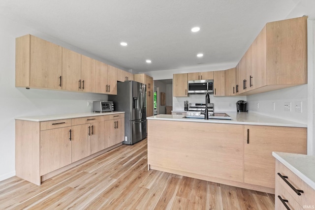 kitchen featuring light hardwood / wood-style flooring, stainless steel appliances, and light brown cabinets