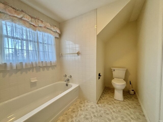 bathroom with a tub to relax in, toilet, and tile patterned floors