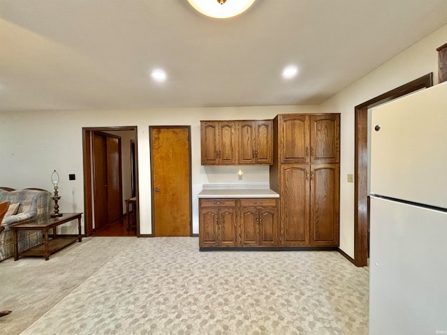 kitchen with light carpet and white refrigerator