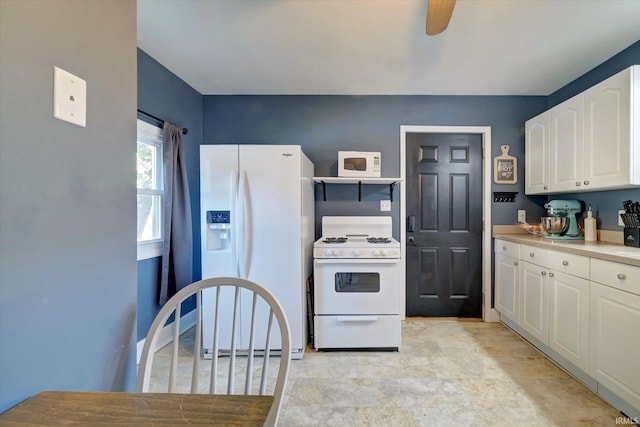 kitchen with white appliances, ceiling fan, and white cabinets