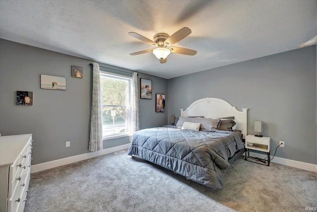 bedroom featuring a textured ceiling, light colored carpet, and ceiling fan