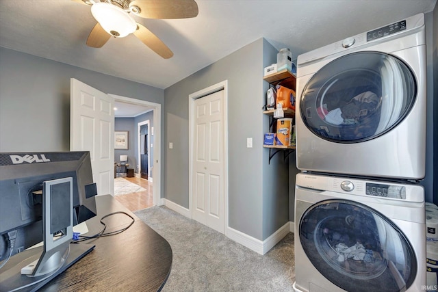 clothes washing area with ceiling fan, light colored carpet, and stacked washer / drying machine