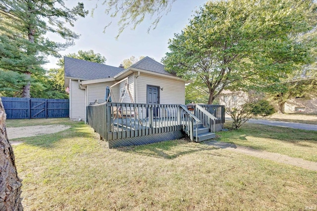 back of property featuring a lawn and a wooden deck