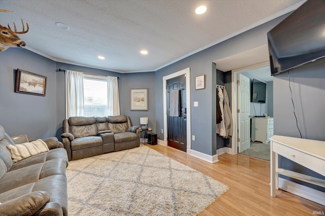 living room featuring hardwood / wood-style flooring, crown molding, and a textured ceiling